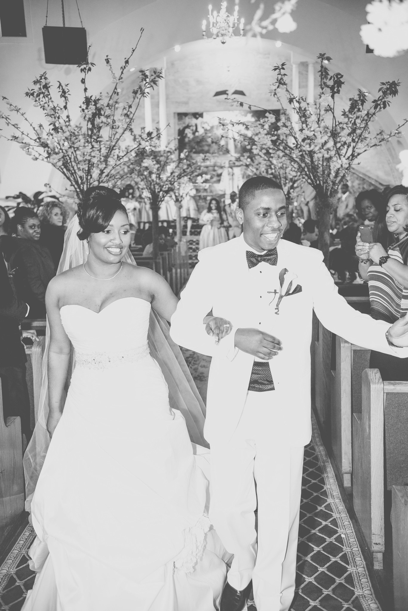 A bride and groom walk back up the aisle, guests on either side